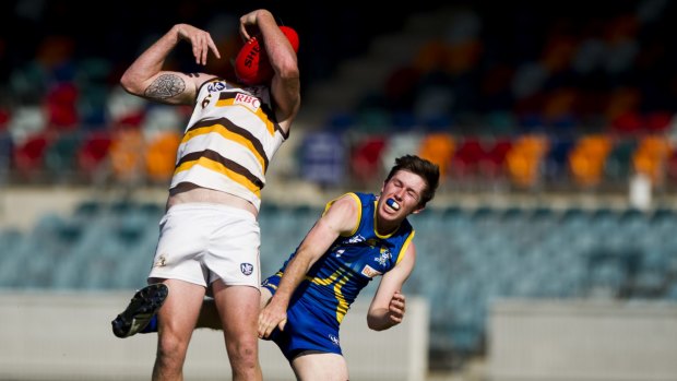 Demons player Declan Bevan can't spoil this Aspley player, whose head seems to have turned into a football.