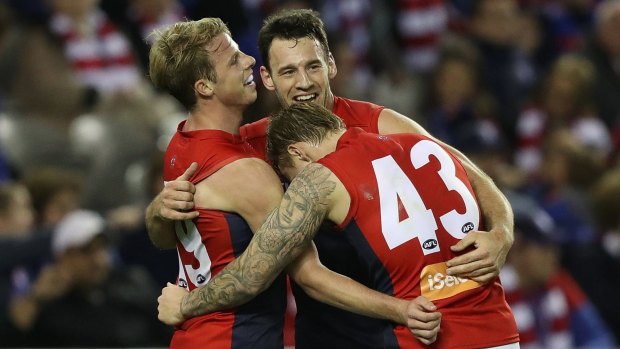 Good spirits: Mitch Hannan celebrates with teammates as Melbourne move up to fifth on the AFL ladder.