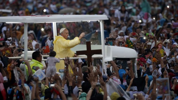 "We need to care for our young": Pope Francis waves to the crowd.