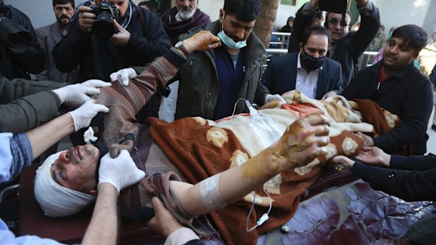 People carry an injured man into the hospital after the suicide attack.