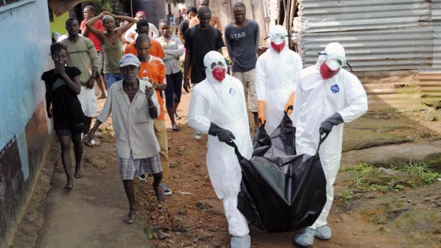 Red Cross health workers remove the  body of a suspected Ebola victim from a home in Monrovia, Liberia. 