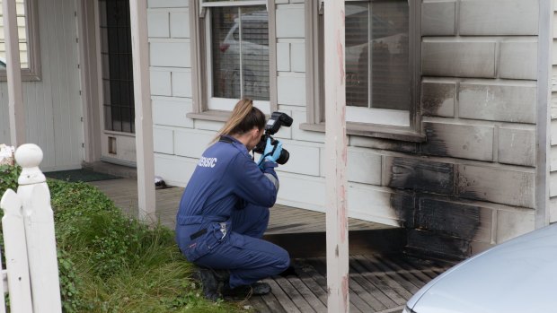 Forensic police photograph the damage at the Albion Street house in Essondon. 