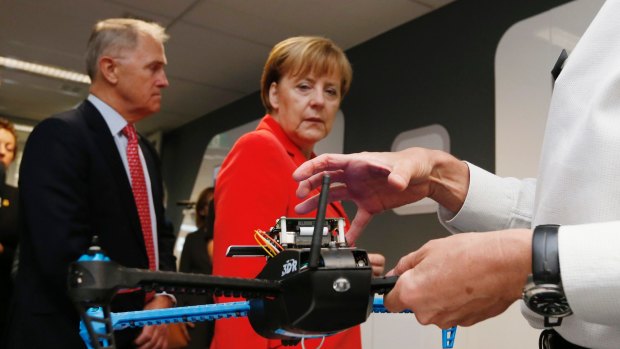 Germany's Chancellor Angela Merkel looks at a drone prototype during a tour of NICTA's Future Logistics Living Lab.     