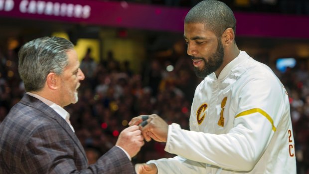 Kyrie Irving accepts his NBA championship ring.