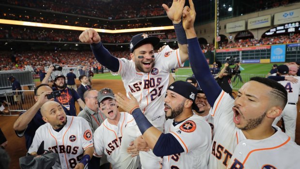 Houston's Jose Altuve is lifted by teammates after game seven.
