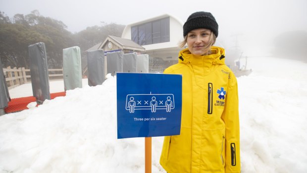 Mt Buller staff member Kate Moffatt displays the social distancing measures the resort will use on their ski lifts.