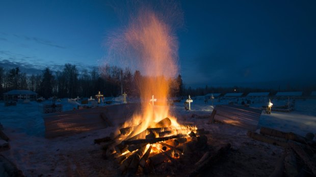 A fire burns to thaw the frozen ground so a grave can be dug for one of the mass shooting victims in La Loche, Saskatchewan, in January.