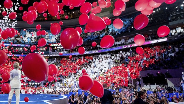 Balloons fall as Hillary Clinton stands on stage during the fourth day of the Democratic National Convention.