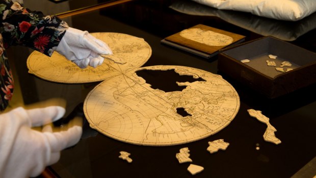Curator Sarah Morley with an antique globe jigsaw puzzle.