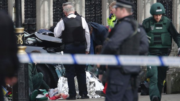 Emergency personnel tend to an injured person close to the Palace of Westminster, London.
