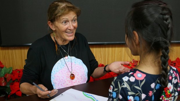 Bronwyn Bancroft signs a drawing for a student in Beijing.