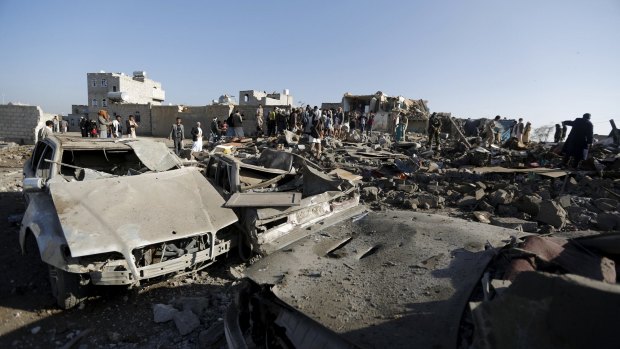People gather at the site of an air strike in Yemen's capital, Sanaa.