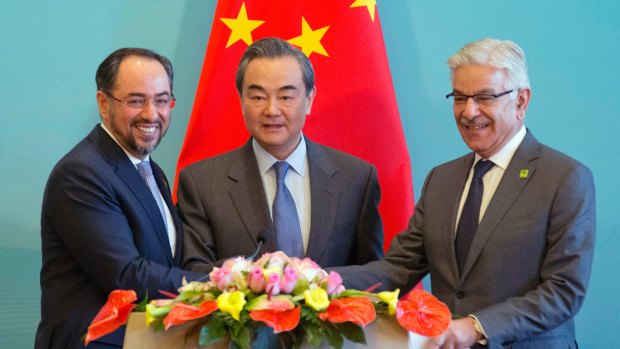 Looking elsewhere for support: From left, Afghanistan Foreign Minister Salahuddin Rabbani, Chinese Foreign Minister Wang Yi and Pakistani Foreign Minister Khawaja Asif hold hands after a press conference for the 1st China-Afghanistan-Pakistan Foreign Ministers' Dialogue held in Beijing on Boxing Day.