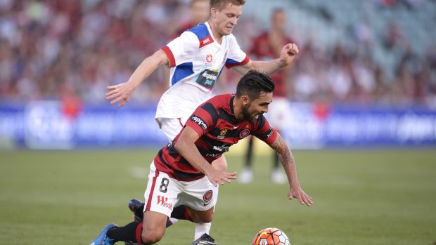 Dimas Delgado of the Wanderers is tackled by Ryan Kitto of the Jets.