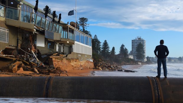 A Collaroy local surveys the damage to The Collaroy Beach Hotel on Tuesday. 