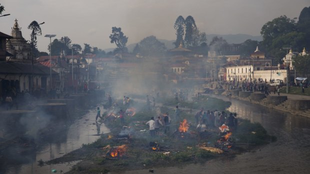 Flames rise from burning funeral pyres during the cremation of victims of the earthquake.
