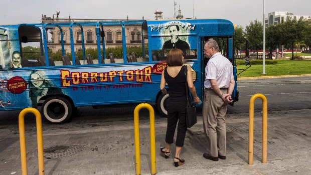 Two members of Via Ciudadana wait to begin one of the Corruptour bus' free tours.