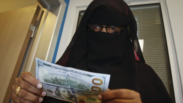 A Somali woman counts the money she collected from a money-transfer service in Mogadishu.