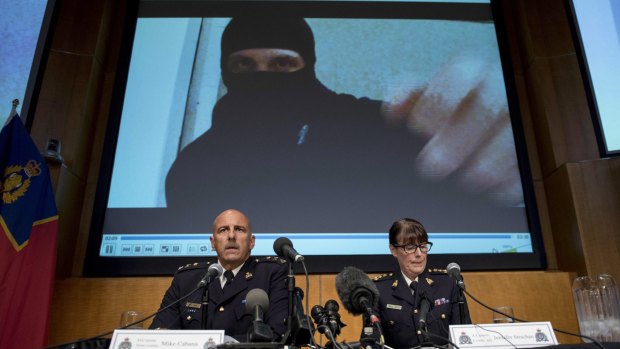 Video footage showing Aaron Driver is seen behind Royal Canadian Mounted Police Deputy Commissioner Mike Cabana, left, and Assistant Commissioner Jennifer Strachan in Ottawa on Thursday.