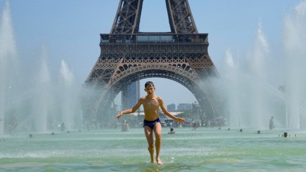 July 19, 2022: Parisians and tourists cool off from the heat by going in the Trocadero Garden Fountain.