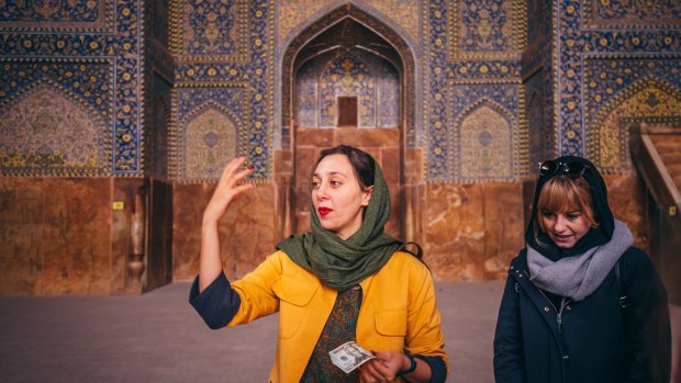 Intrepid local leader Nadia Badiee uses a dollar bill to demonstrate the strange acoustics inside Shah Mosque, Esfahan.