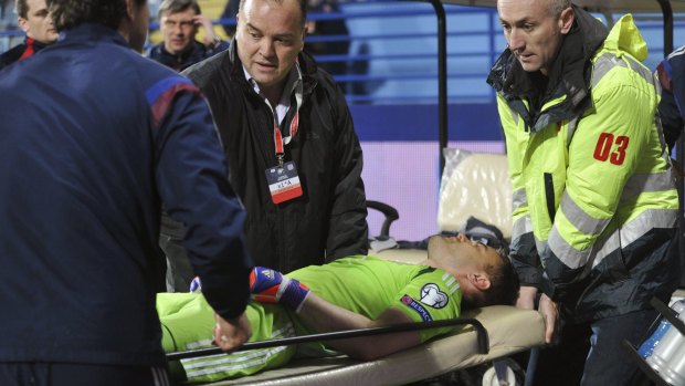 Russia's goalkeeper Igor Akinfeev is taken away on a stretcher after being hit in the head with a flare.