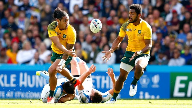 Backline movement: Joe Tomane offloads to Henry Speight during the 2015 Rugby World Cup Pool A match between Australia and Uruguay at Villa Park.