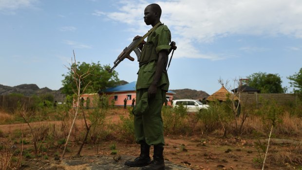 A rebel soldier stands guard as his comrades arrive at a camp on the outskirts of Juba, South Sudan, in April.