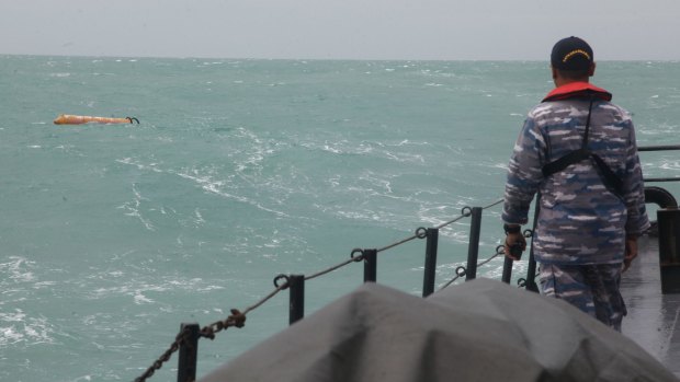 Time: A member of the Indonesian Navy looking towards a part believed to be from the AirAsia flight.