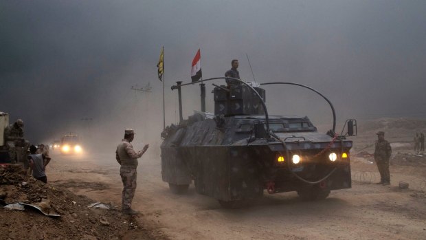 An Iraqi Federal Police vehicle passes through a checkpoint in Qayara,  south of Mosul.