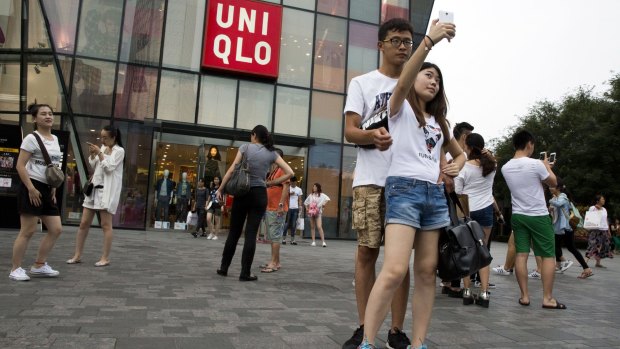 A couple take a selfie outside the Uniqlo flagship store in Beijing.