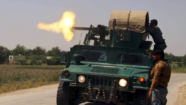 Policemen fire from an armoured vehicle during a battle with Taliban insurgents in Kunduz province on Sunday. 