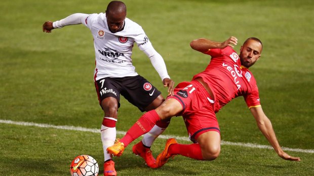 Close encounter: Romeo Castelen of the Wanderers is tackled by Tarek Elrich of Adelaide United.