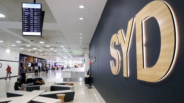 Passengers walk through a near-deserted international arrivals terminal of Sydney Airport.