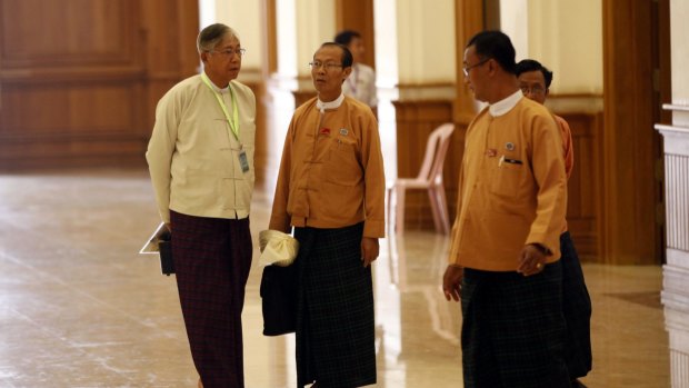Htin Kyaw, left, a National League for Democracy presidential candidate, speaks with NLD MPs in parliament on Monday. 