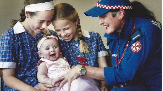 In 2008 - Laura, 12, Caitlin, 10, with baby Ella Bishop, 19 weeks, and Albury paramedic Fiona Dillon.