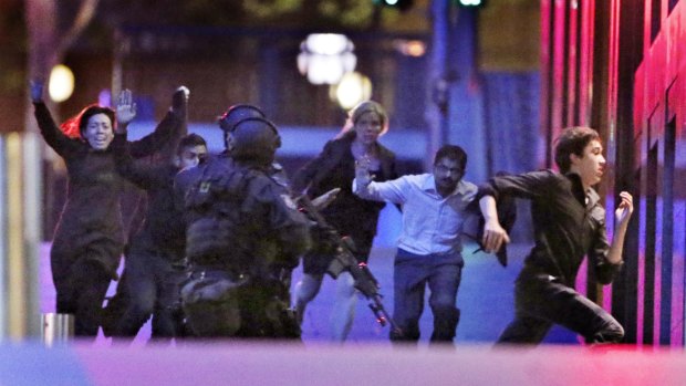 Hostages run from the Lindt Cafe siege in December 2014.