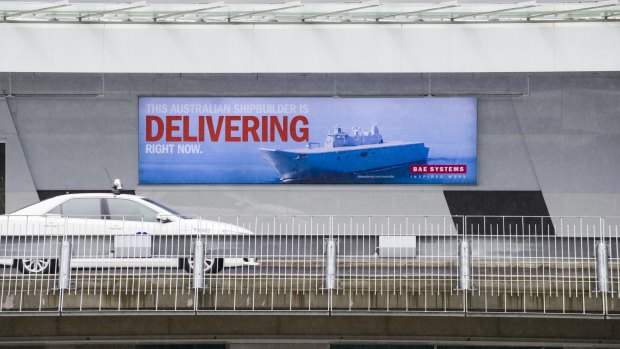 An advertising poster featuring a warship at Canberra Airport. 