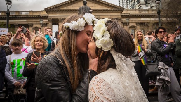 A couple perform a mock wedding ceremony at a rally in Melbourne supporting a yes vote.