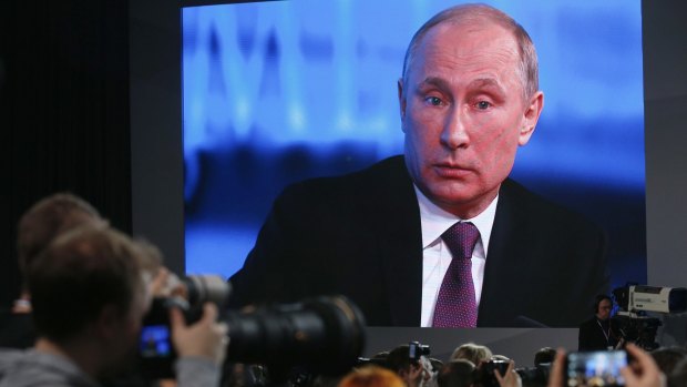 Vladimir Putin is seen on a screen during his annual end-of-year news conference in Moscow on Thursday.