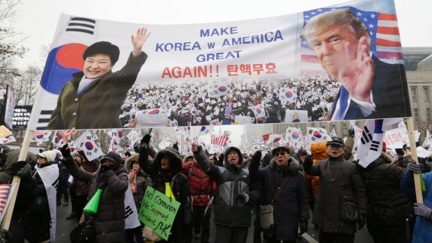 Supporters of South Korean President Park Geun-hye wave flags during a rally in Seoul on Saturday, opposing Park's impeachment.