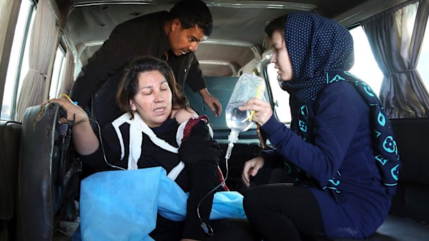 People assist an injured woman following the attack. 