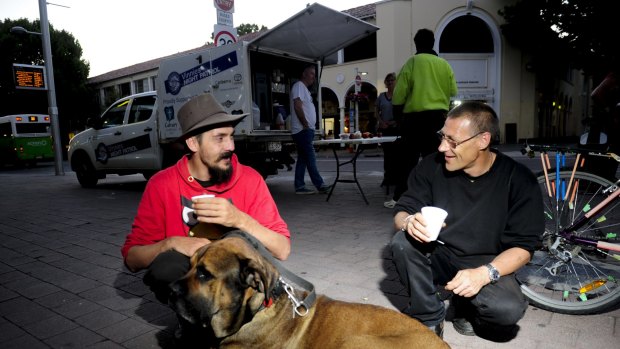 Michael Sobozinski, left, and Randy Booth with dog Bear  use the services provided by the Vinnies Night Patrol van which was set up near Garema Place in Civic. 