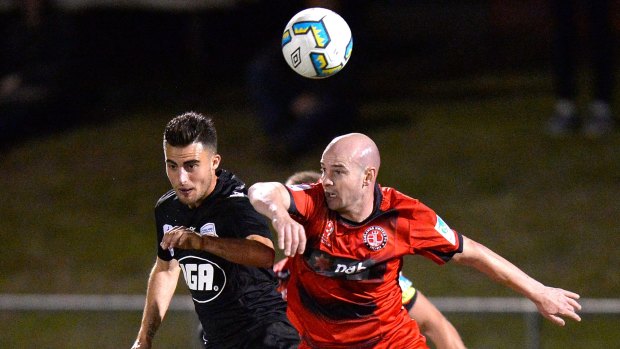 Russell Woodruffe of Redlands United and Adelaide's Jesse Makarounas compete for the ball at Brisbane's Perry Park.