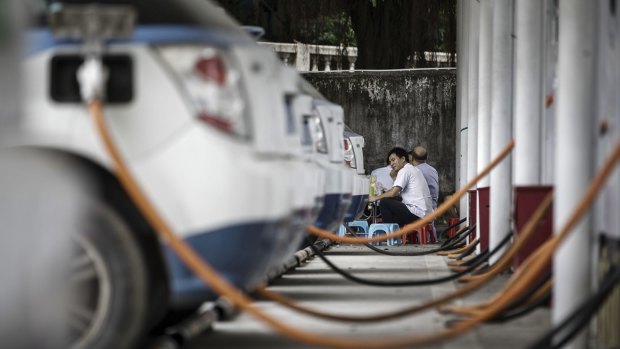 Charging cables connect to a row of electric taxis in Shenzhen, China.