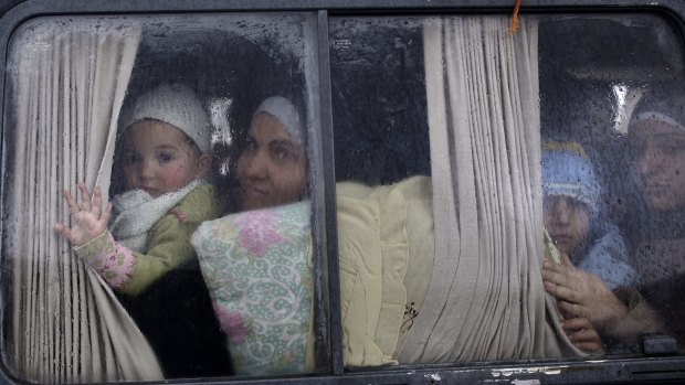 Syrian refugees cross the border from Syria to Turkey on a bus.