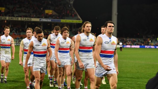 Shellshocked: The Bulldogs walk off the field after a thumping at Adelaide Oval.