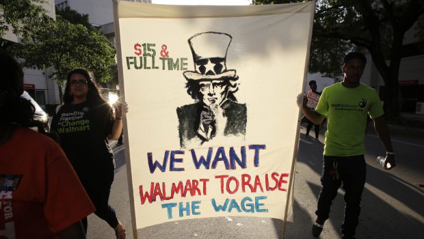Protesters in Miami march in support of raising the minimum wage to $US15 an hour. Hillary Clinton, with an eye to her party's left wing, has placed an early emphasis on social equity.