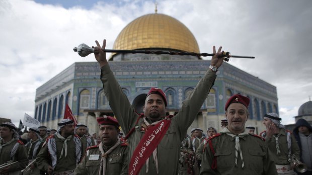 A member of the Palestinian scouts raises a baton during a ceremony to commemorate the birth of the Prophet Muhammad outside the Dome of the Rock in Israeli-occupied East Jerusalem. 
