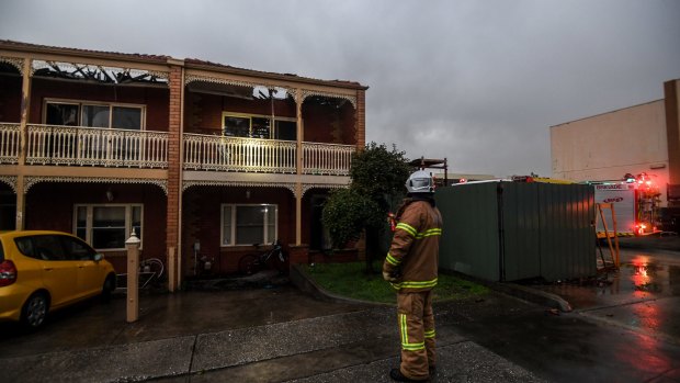 /A firefighter assesses the four townhouses destroyed by fire in Hope Street, Brunswick.